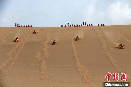 6月13日，敦煌鳴沙山月牙泉景區(qū)舉辦滑沙比賽。　張曉亮 攝