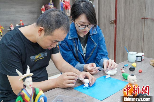 <a target='_blank'  data-cke-saved- >中新社</a>記者(右)現(xiàn)場體驗面塑制作過程。　陳爭強 攝