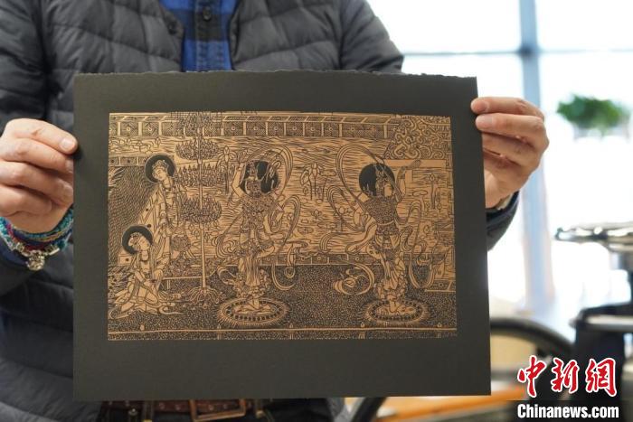 圖為手工書藝人展示敦煌雕版壁畫印刷品?！【琶赖┰?　攝