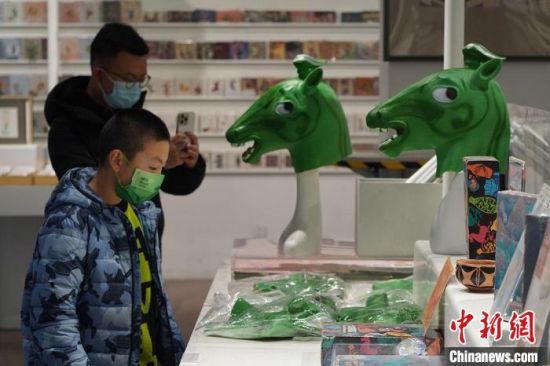 圖為“神馬來(lái)了”銅奔馬頭套吸引參觀者駐足?！【琶赖┰?攝