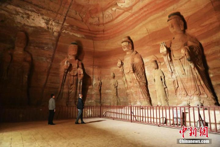 7月15日，游人參觀甘肅省平?jīng)鍪袥艽h百里石窟長廊中的南石窟寺1號窟。百里石窟長廊位于涇川縣境內(nèi)，由512個石窟、5眼窟中石井組成，現(xiàn)存王母宮石窟、鳳凰山石窟、南石窟寺、丈八寺石窟、羅漢洞石窟、太山寺石窟等規(guī)模較大的石窟群，還有數(shù)量眾多的小石窟群。南石窟寺開鑿于北魏永平三年，其中1號窟屬于大型七佛窟，七佛高達6米。中新社記者 李亞龍 攝